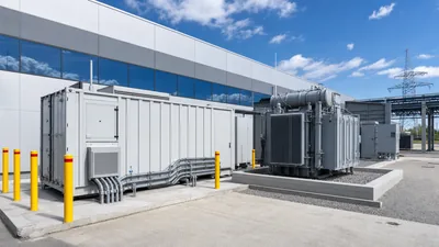 Industrial battery storage system mitigating demand charge electricity spikes at a manufacturing plant