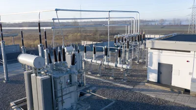 High-voltage electric substation featuring power transformers, circuit breakers, and busbar equipment