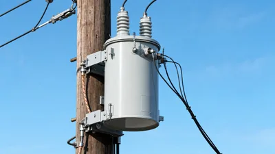 Single phase pole mounted transformer installed on a utility pole with primary and secondary distribution lines