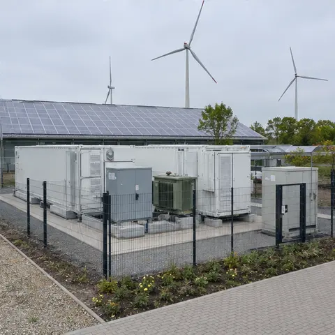 Completed and fenced battery storage installation with container, power conversion system and transformer